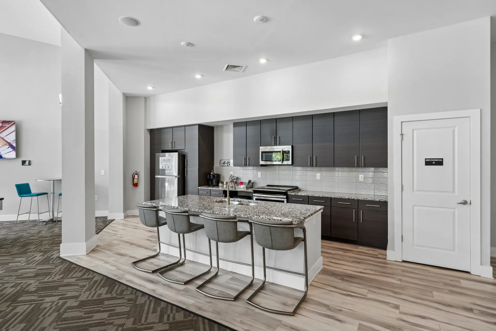 Modern kitchen with granite island and bar stools at Willows at the University in Charlotte, NC.