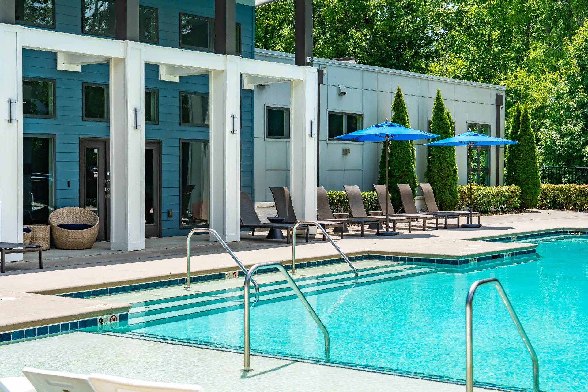 Resort-style swimming pool with lounge chairs and umbrellas at Willows at the University in Charlotte, NC.