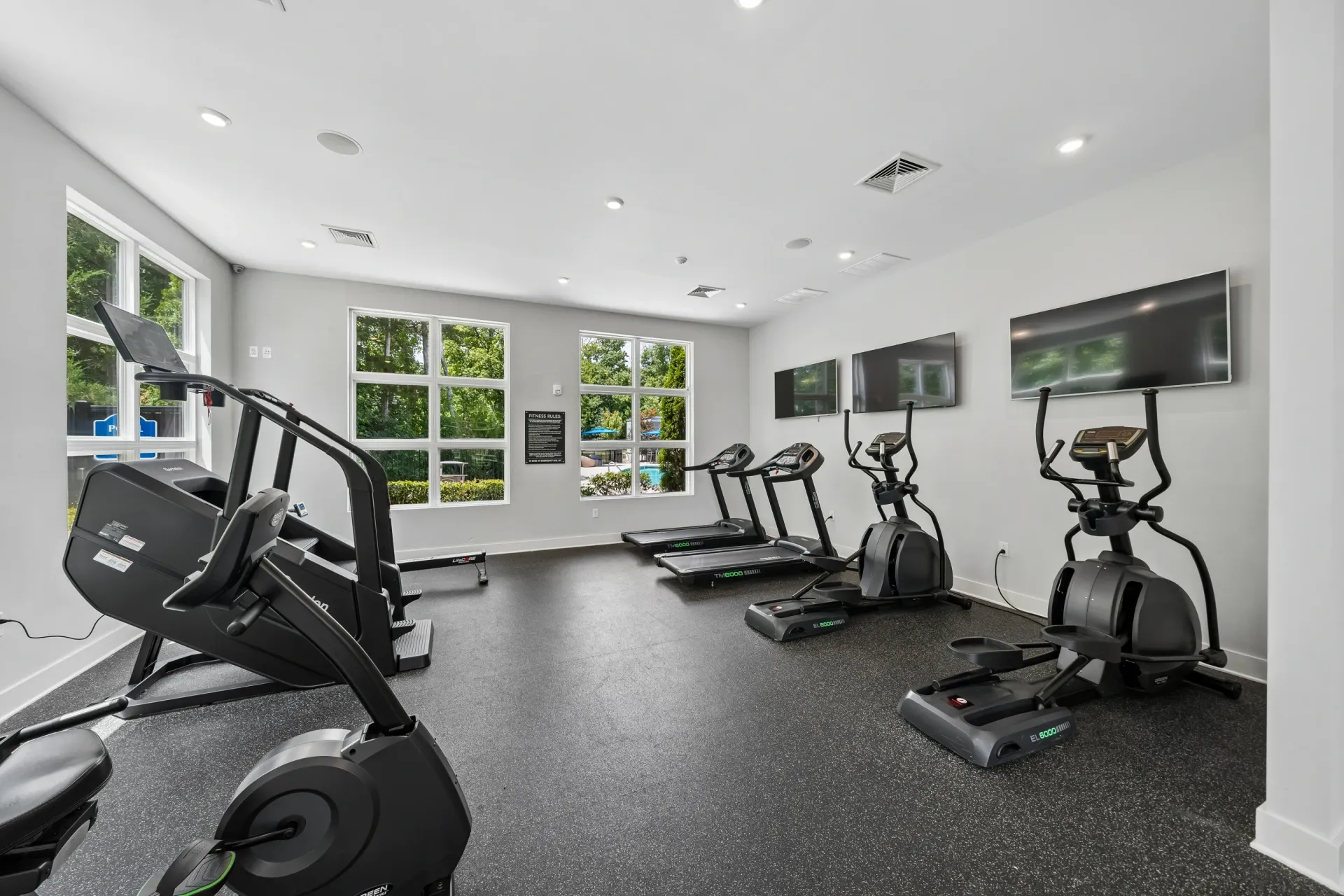 Modern apartment complex fitness center with treadmills, ellipticals, and a stair climber at Willows at the University in Charlotte, NC.