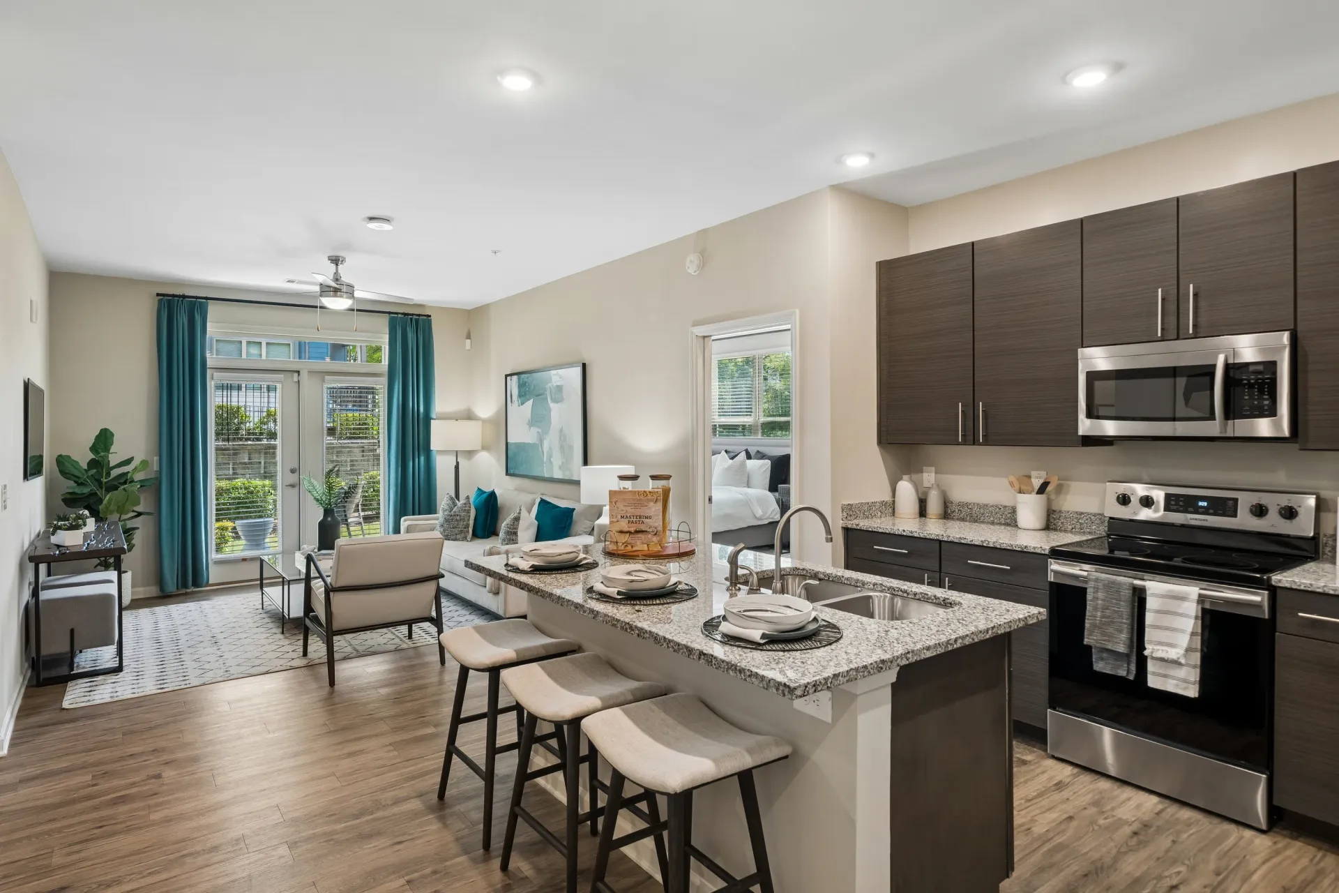 Open concept living area with kitchen island and living room at Willows at the University in Charlotte, NC.