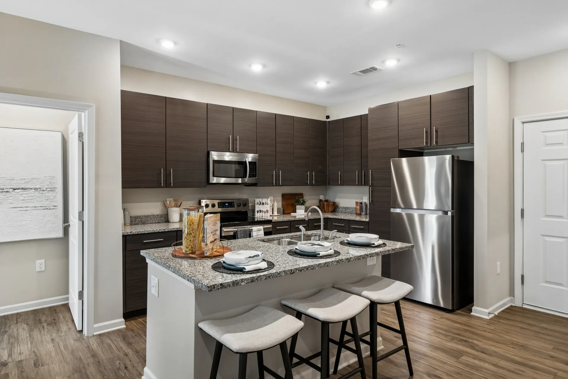 Modern kitchen with stainless steel appliances and granite countertops.