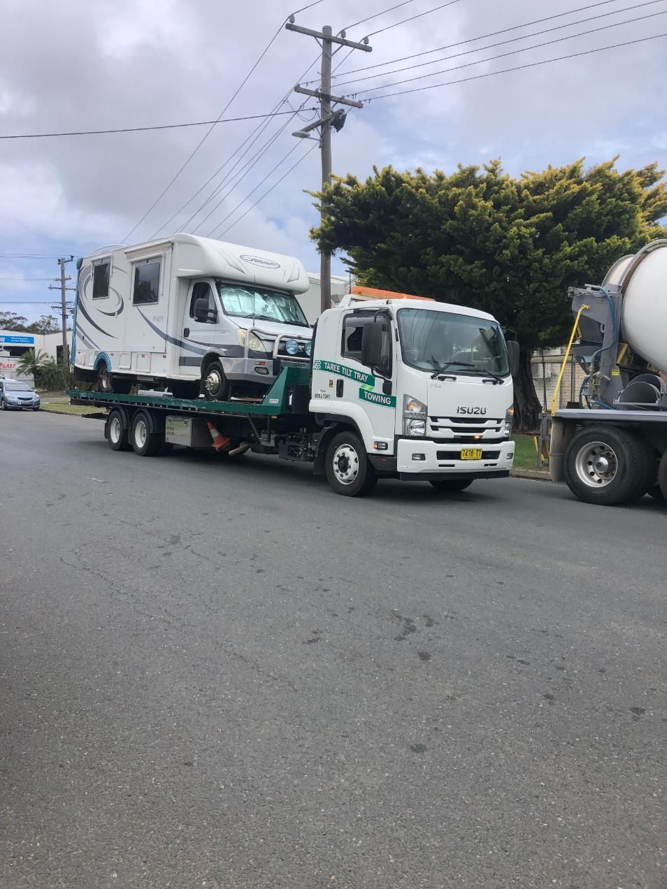 A Tow Truck Is Carrying A Camper On The Back Of It — Taree Tilt Tray Towing In Taree, NSW