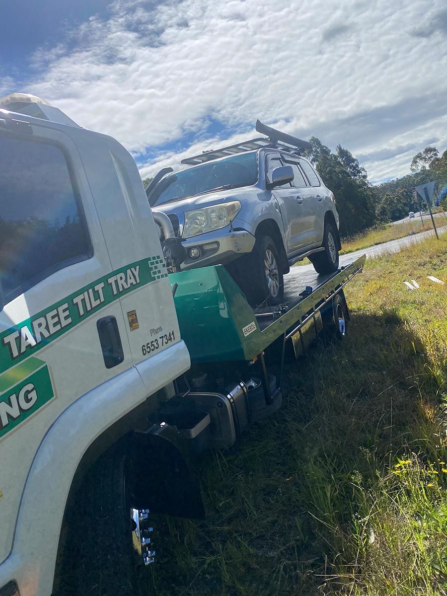 A Car is Being Towed by a Tow Truck — Taree Tilt Tray Towing In Taree, NSW