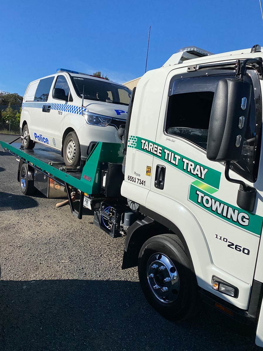 A White Towing Truck Is Towing A White Van — Taree Tilt Tray Towing In Wootton, NSW
