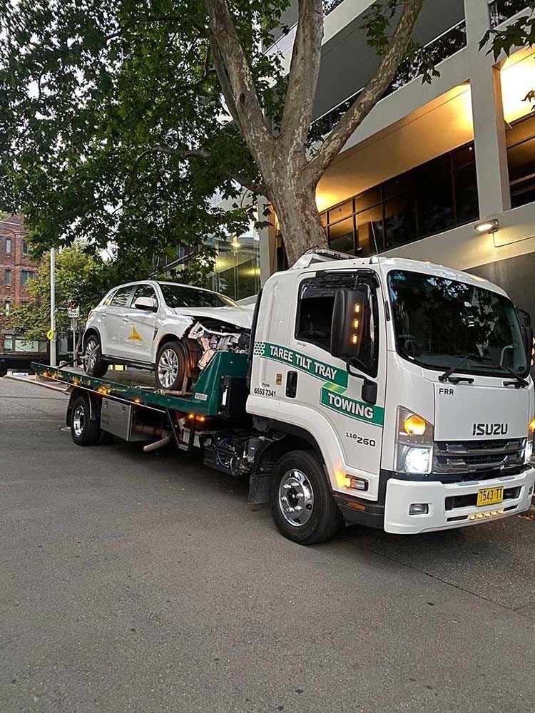 A Tow Truck is Towing a Car on the Back of It — Taree Tilt Tray Towing In Wingham, NSW