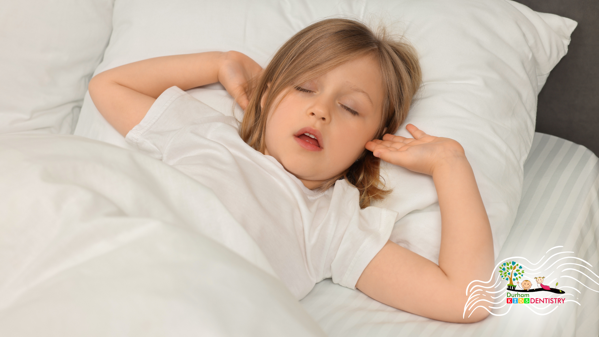 Child sleeping in a white bed with hands behind head and eyes closed