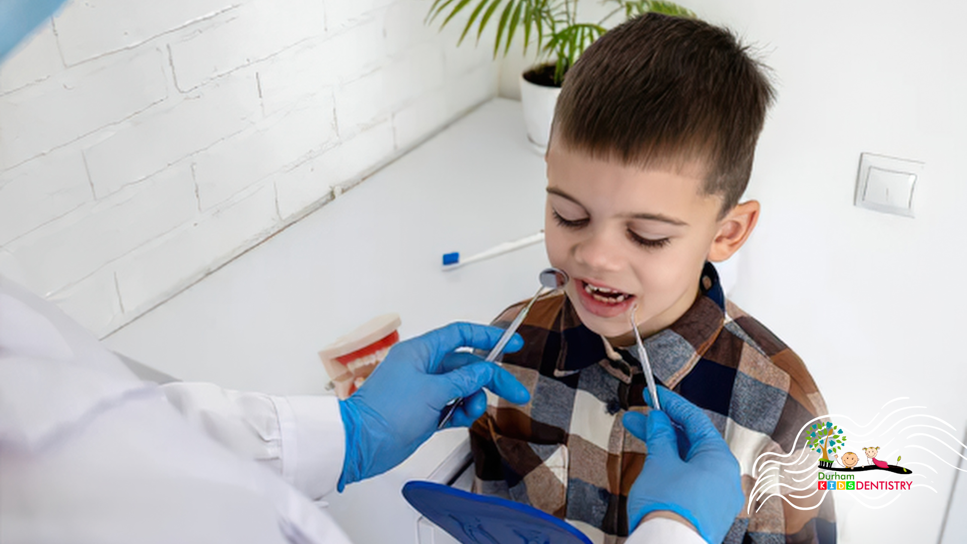 Dental exam: child in plaid shirt opening mouth while gloved clinician checks teeth with tools