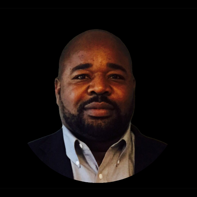Paul a board member, wearing a collared shirt and dark blazer, centered against a solid black background.