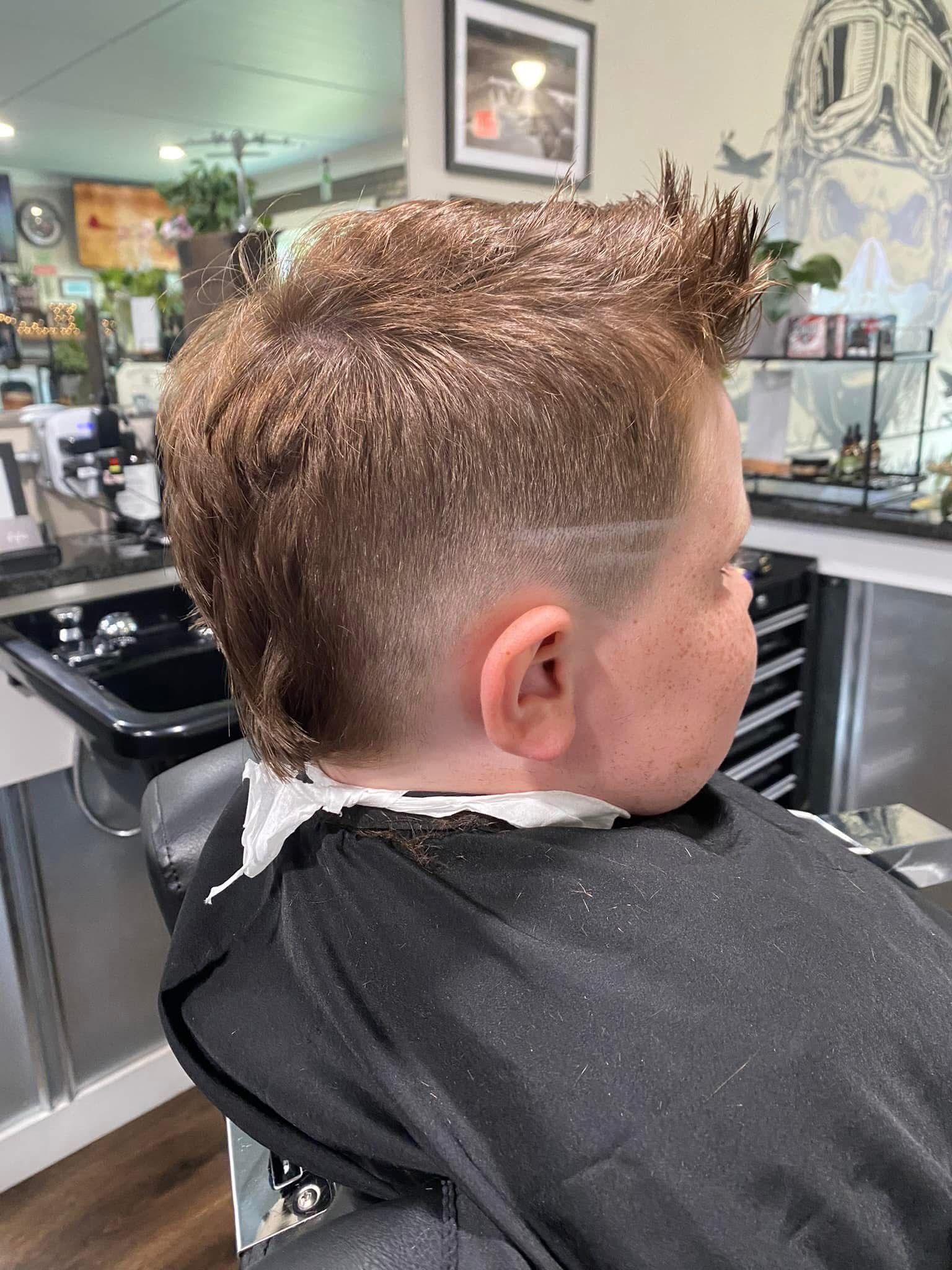 Boy with a fade haircut and a line-up at the barber shop.