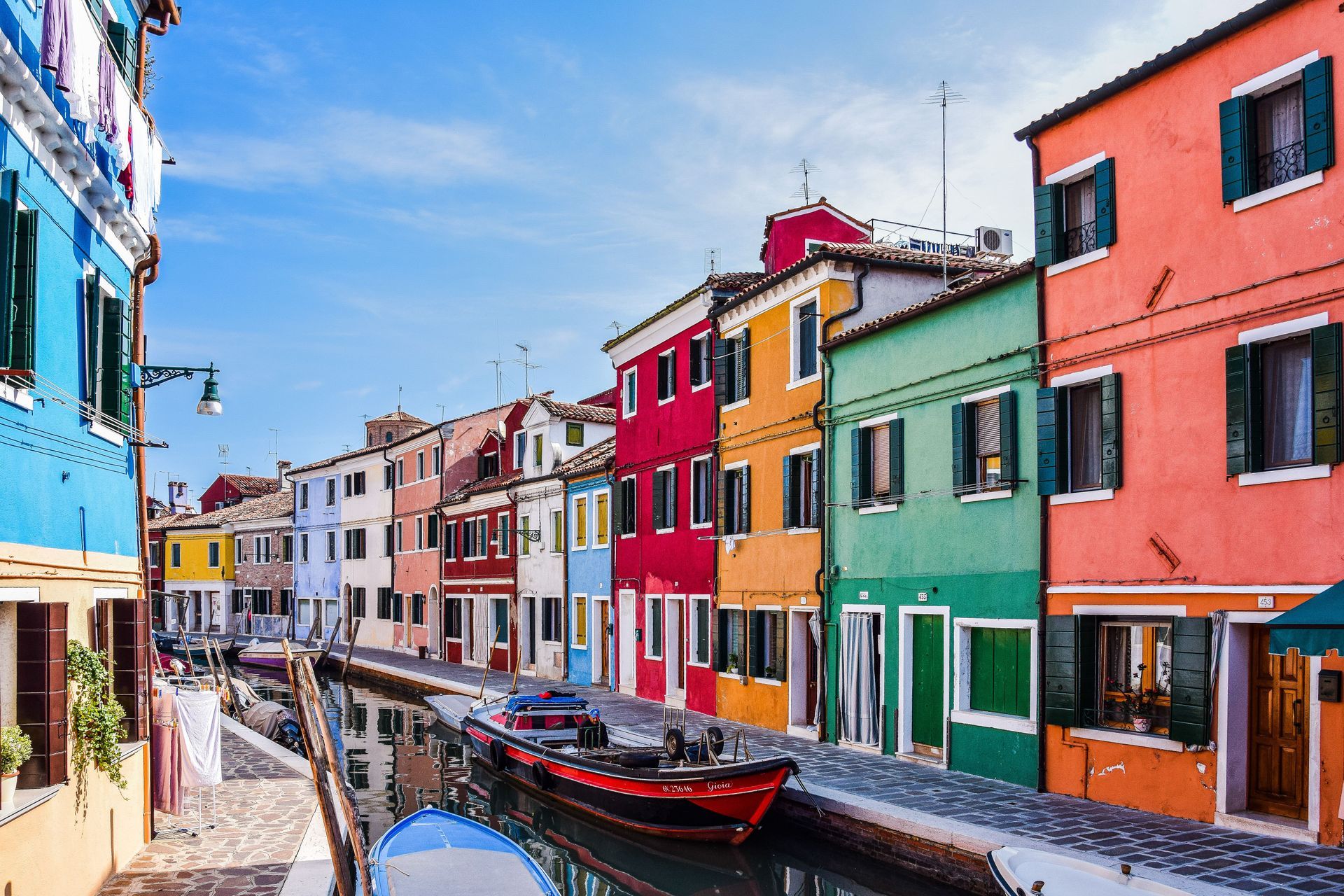 Colorful canal-side buildings and boats in a sunny European street scene
