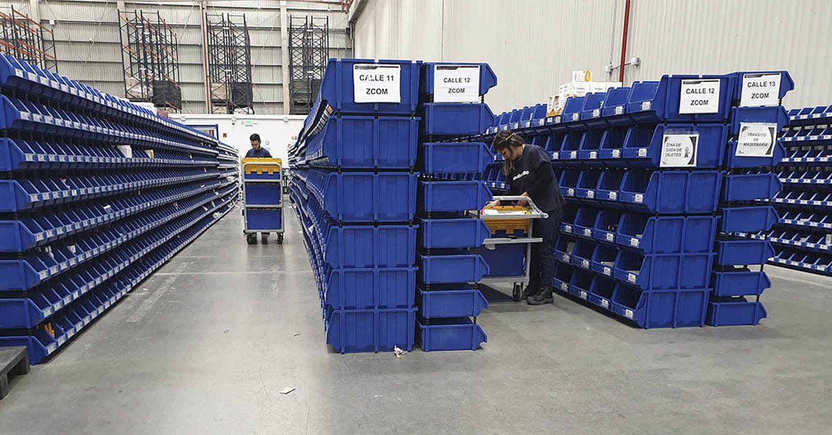 Un almacén lleno de contenedores y estantes azules.