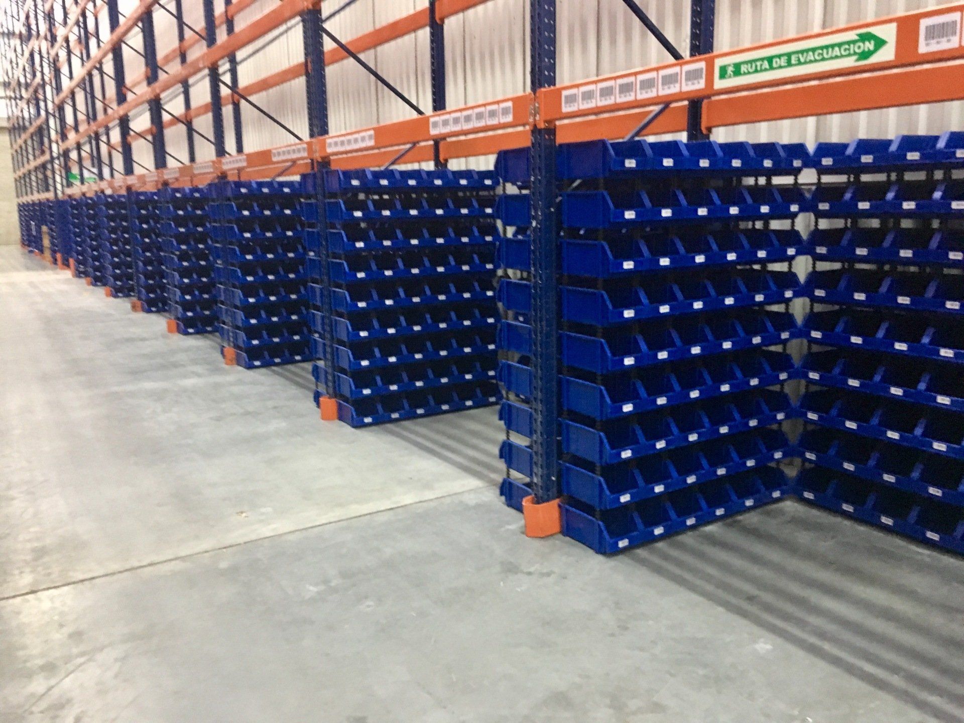 Un gran almacén lleno de contenedores azules.
