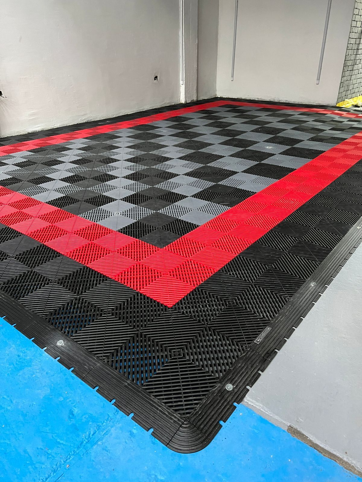 Un suelo a cuadros negros y rojos en un garaje.