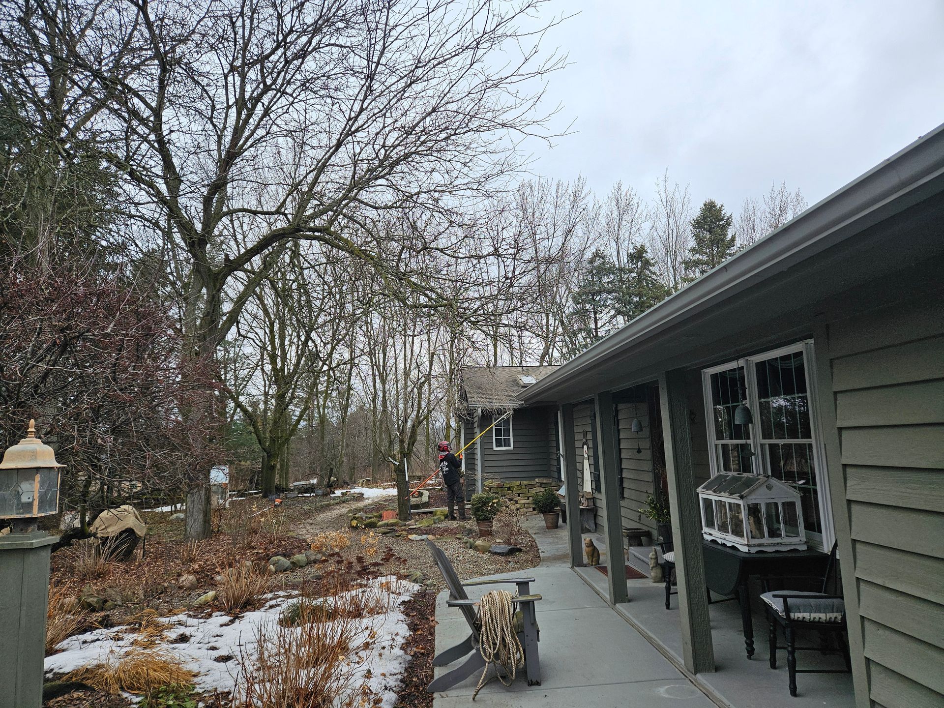 A man is standing on a porch in front of a house.