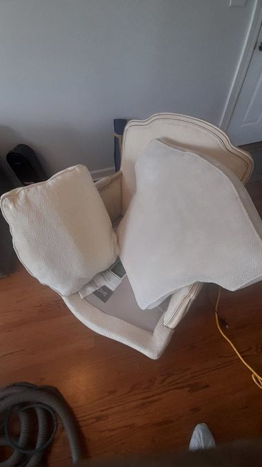 Beige chair cushions and a white pad leaning against a wall on a hardwood floor.