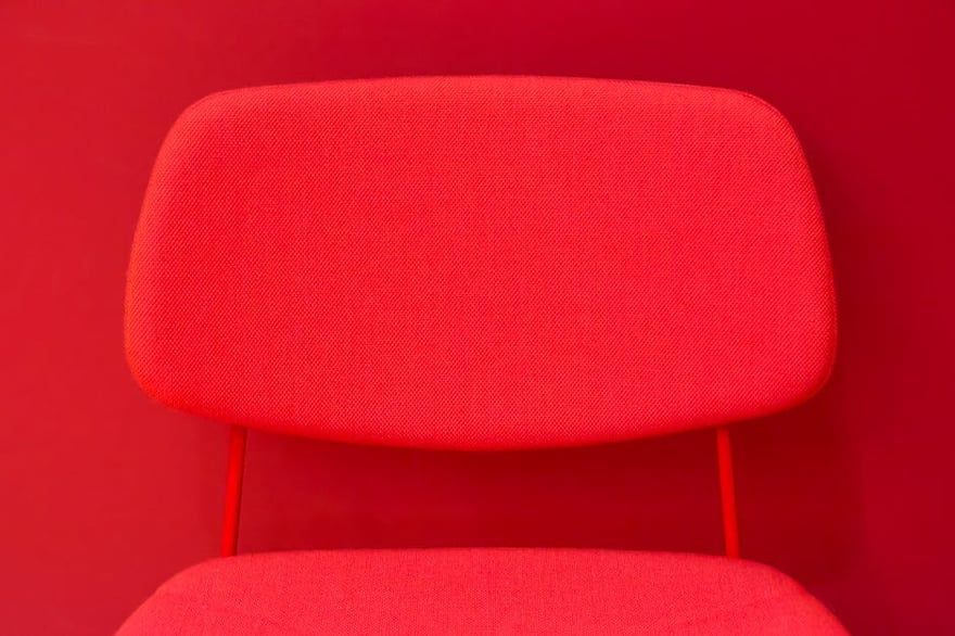 Red upholstered chair against a red background