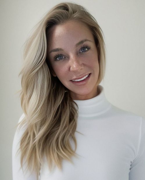 The woman is wearing a white turtleneck and smiling for the camera.