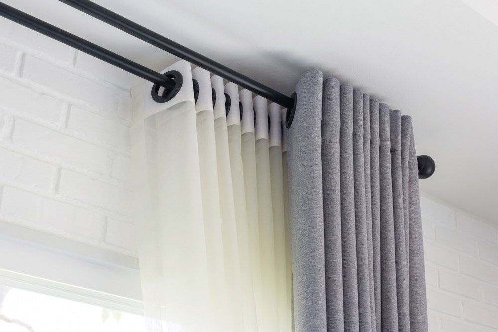 Female Janitor Removing Dust from Curtain — Window Furnishing Services in Burleigh Heads, NSW
