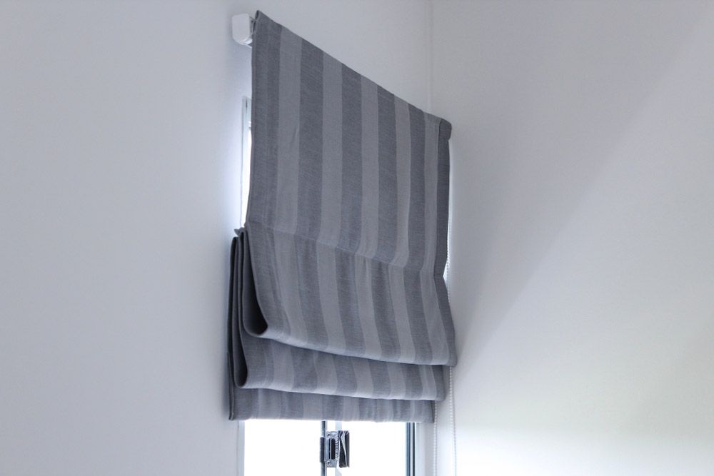 Grey Roman Blind with Strip on The Window — Window Furnishing Services in Currumbin, NSW
