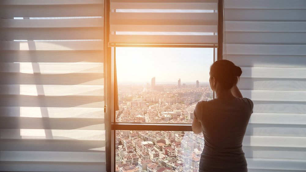 Woman Rolling Up Blinds — Window Furnishing Services in Tallebudgera, NSW