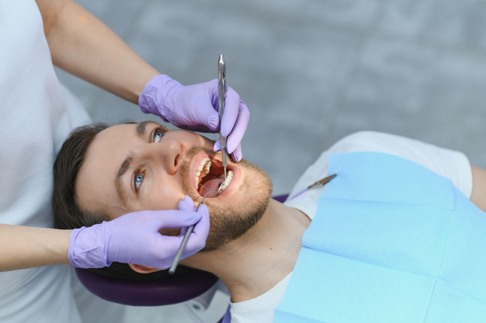 A dentist is working on a patient’s teeth.