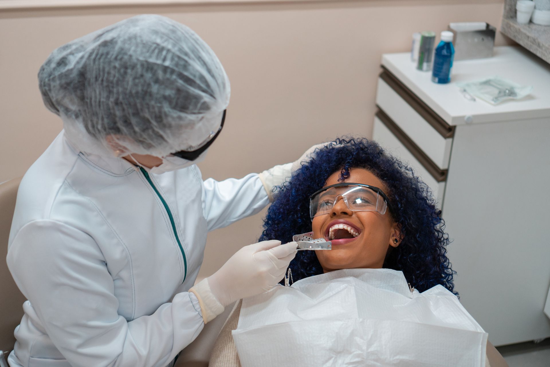 A woman smiling in a dental chair during a general dentistry check-up with her general dentist. A woman smiling in a dental chair during a general dentistry check-up with her general dentist.