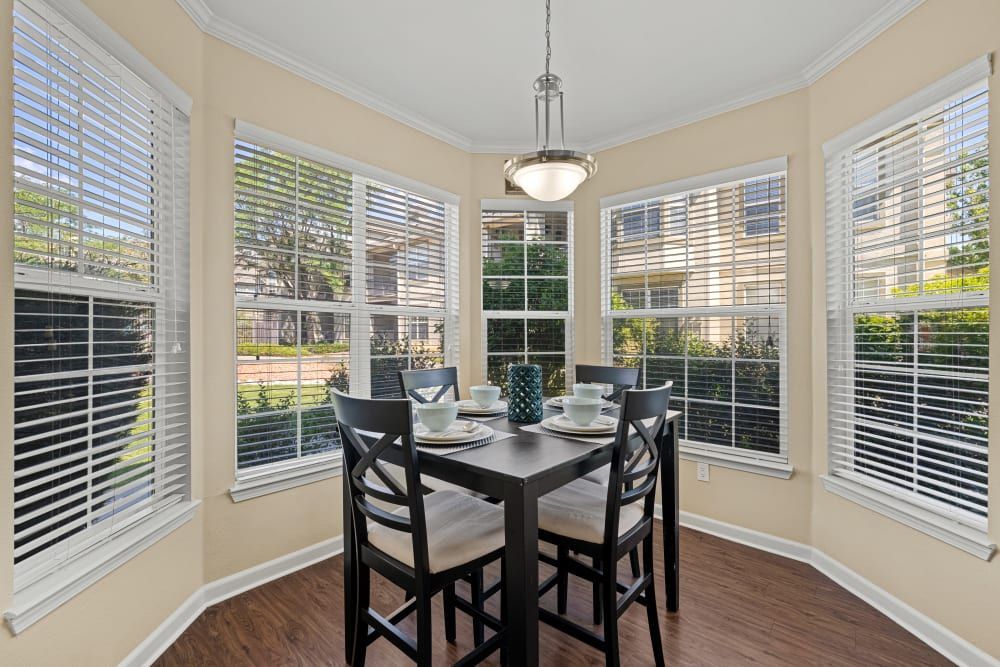 Apartment dining room with a table and chairs and lots of windows at Marquis at Town Centre in Broomfield, CO.