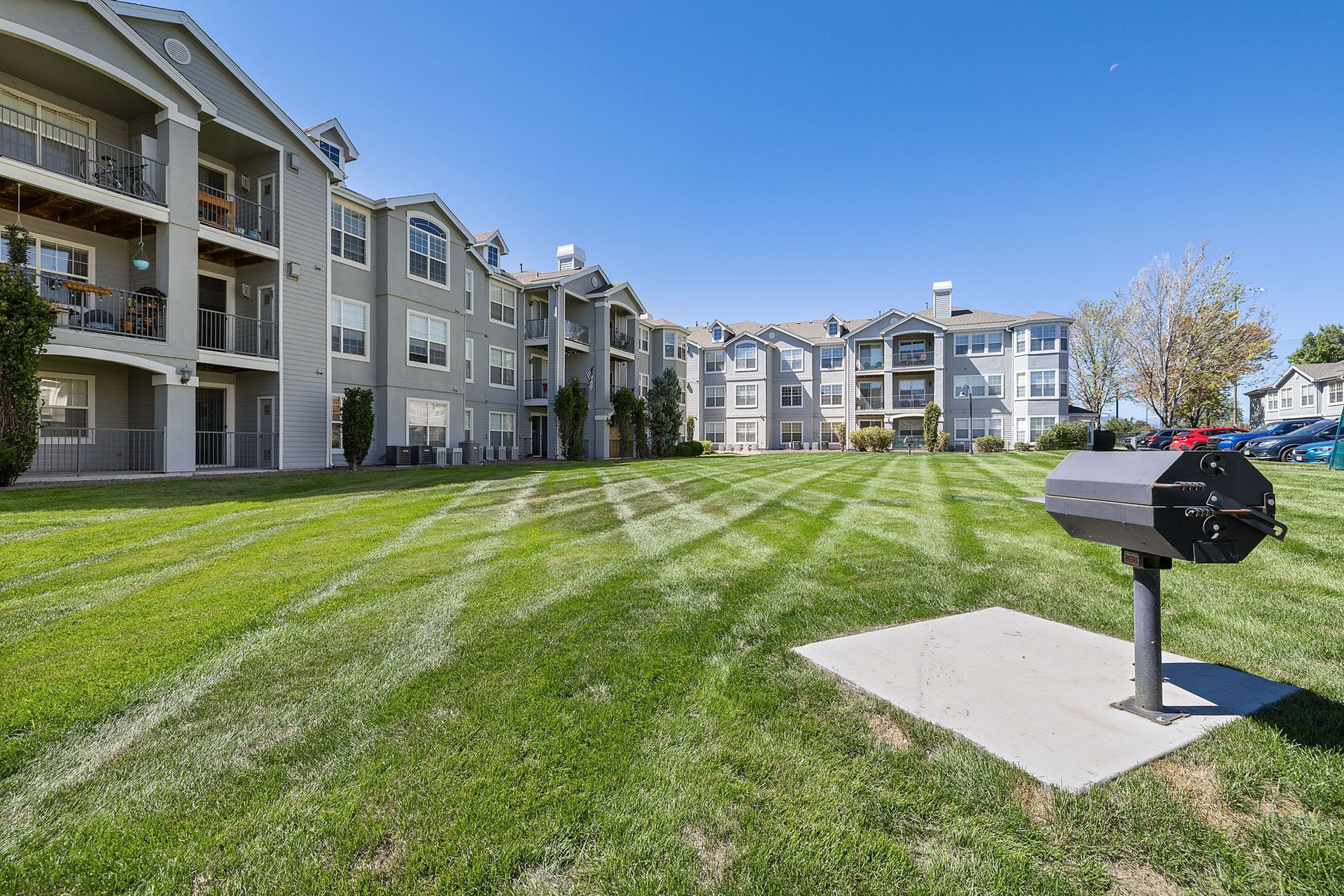 Apartment complex courtyard with green lawn, balconies, and a mailbox at Marquis at Town Centre in Broomfield, CO