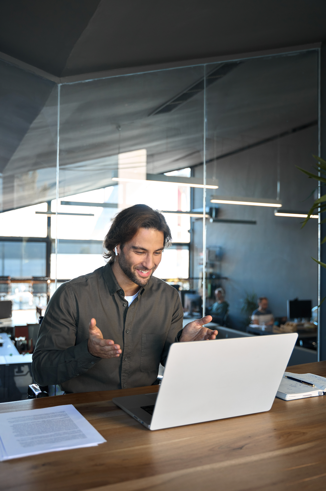 A man is sitting at a desk using a laptop computer.