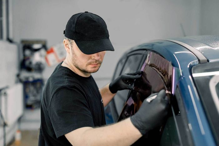 A man applying car window tint