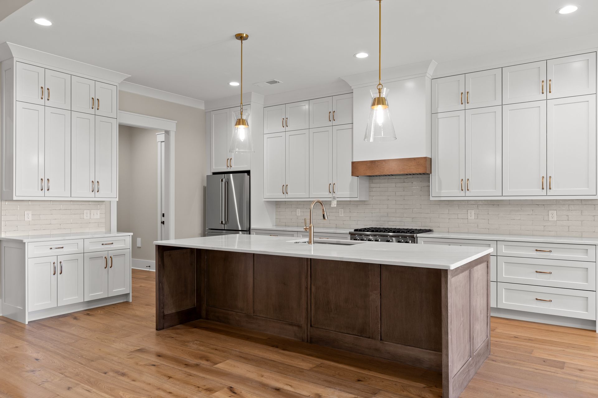 Bright modern kitchen with white cabinets, wood island, and stainless steel appliances