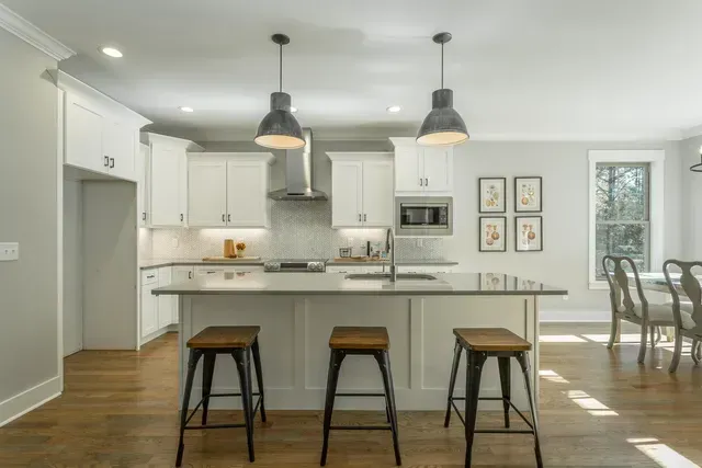 a kitchen with a large island and three stools