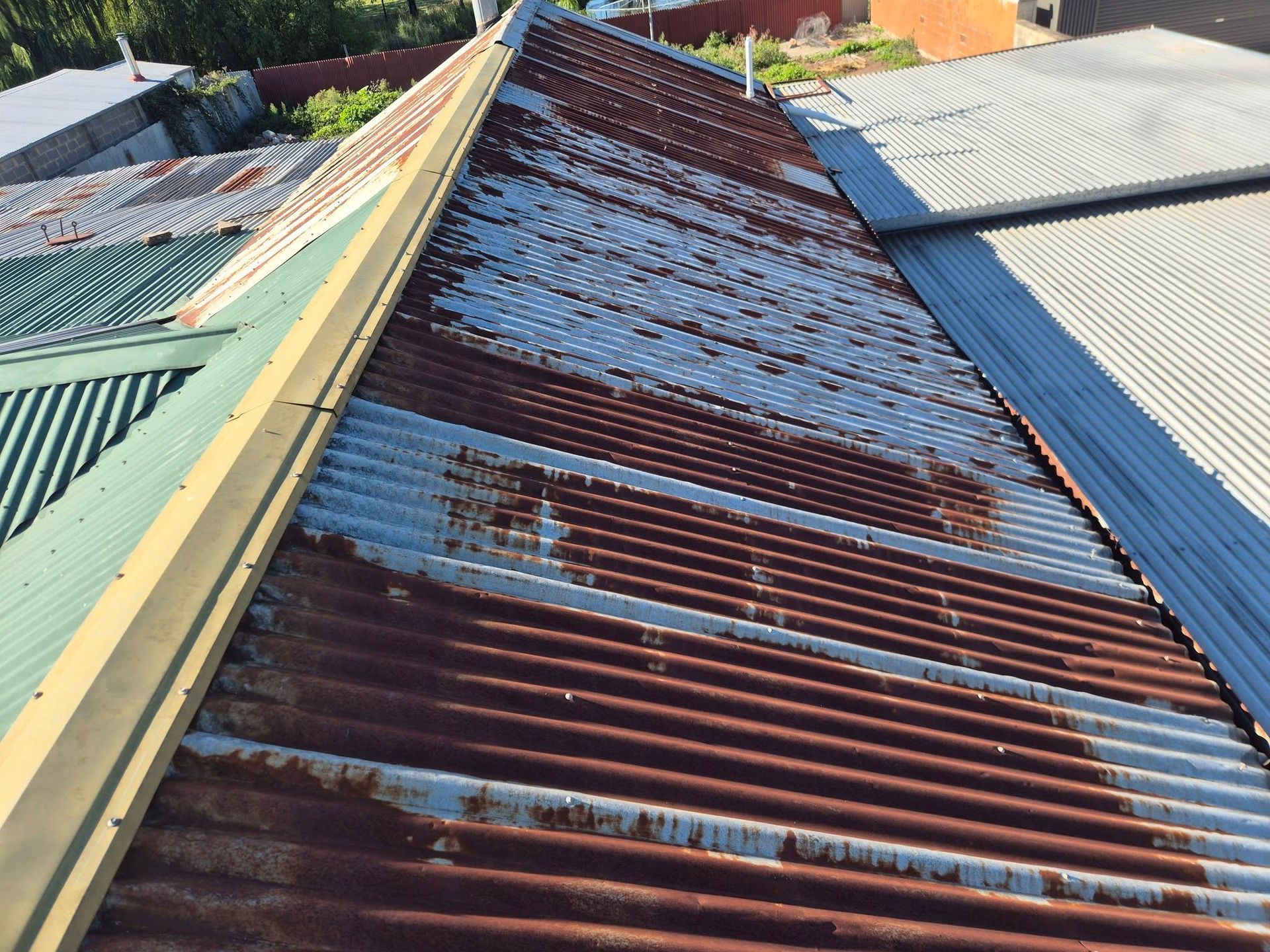Rusted and corroded corrugated iron roof sheeting in need of repair in Wodonga