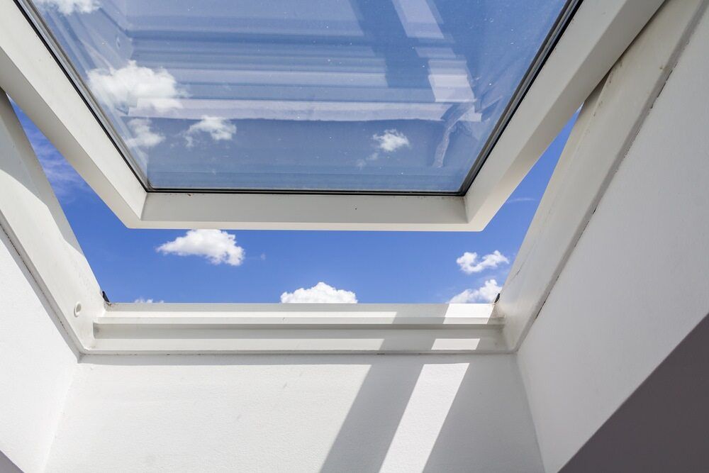 Skylight Looking Up at a Blue Sky With White Puffy Clouds — The Roofer Troopers in Howlong, NSW