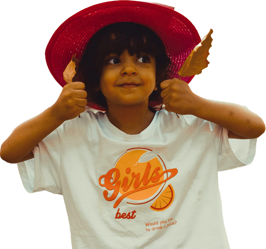 Child wearing a red sunhat and white shirt with orange graphic, giving two thumbs up
