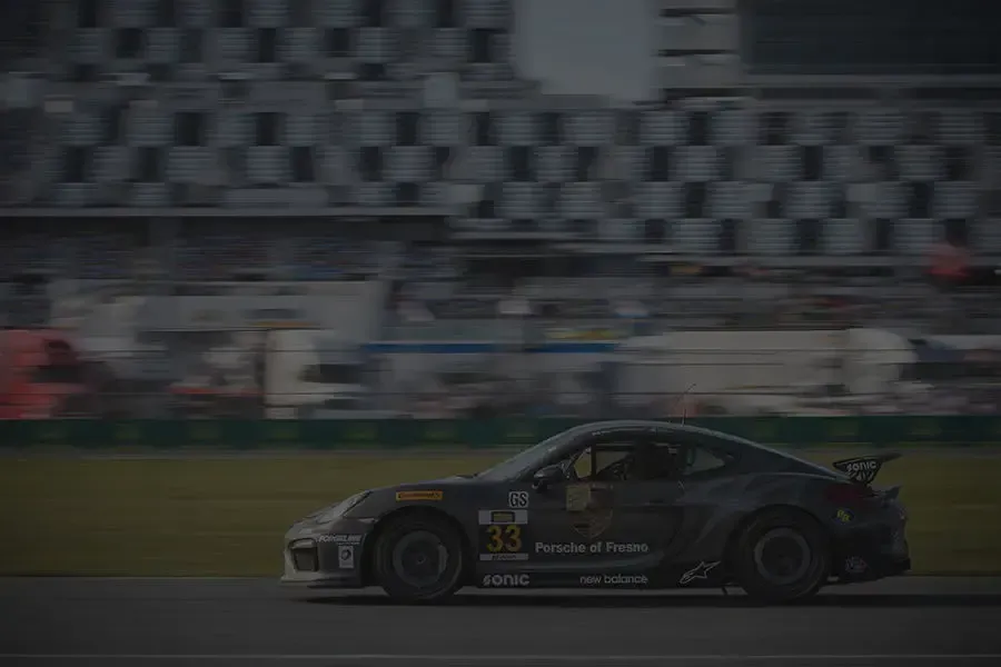 A race car is driving down a race track.