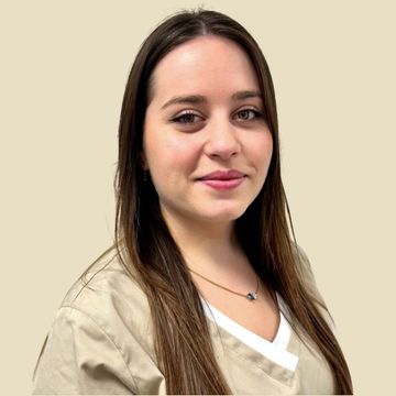 Foto Teammitglied Frau in beigefarbener Kasack, lächelnd, in einem runden Rahmen vor neutralem Hintergrund.