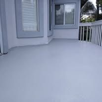 White-painted porch deck with railing, window, and door on a house exterior