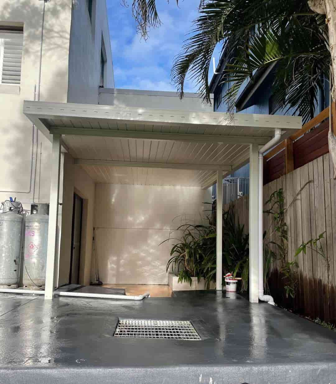 A Car Is Parked Under A Carport In Front Of A House — Caprice Home Additions In Old Bar, NSW