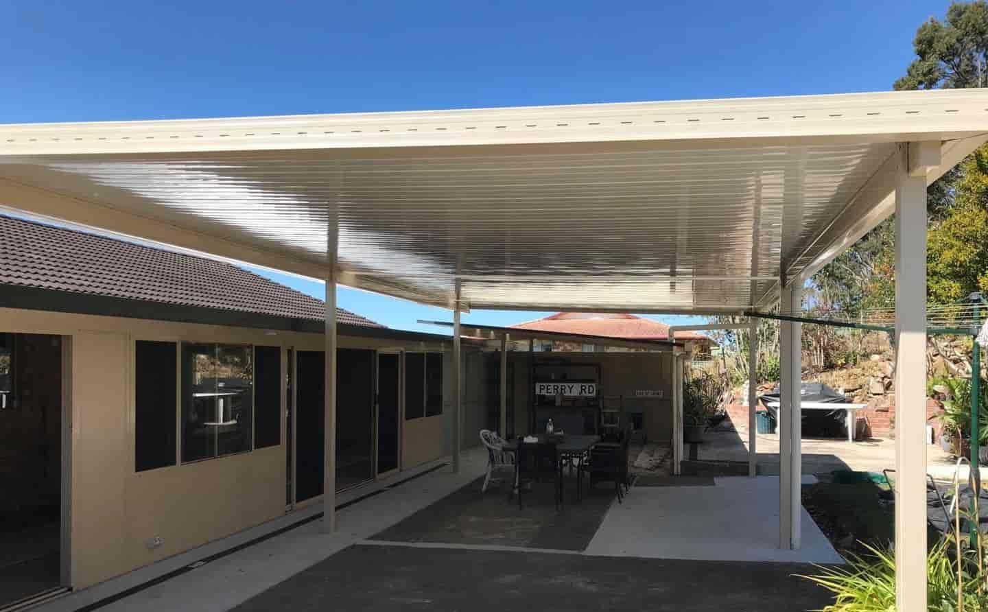 A Carport With A Table And Chairs Underneath It In Front Of A House — Caprice Home Additions In Gloucester, NSW