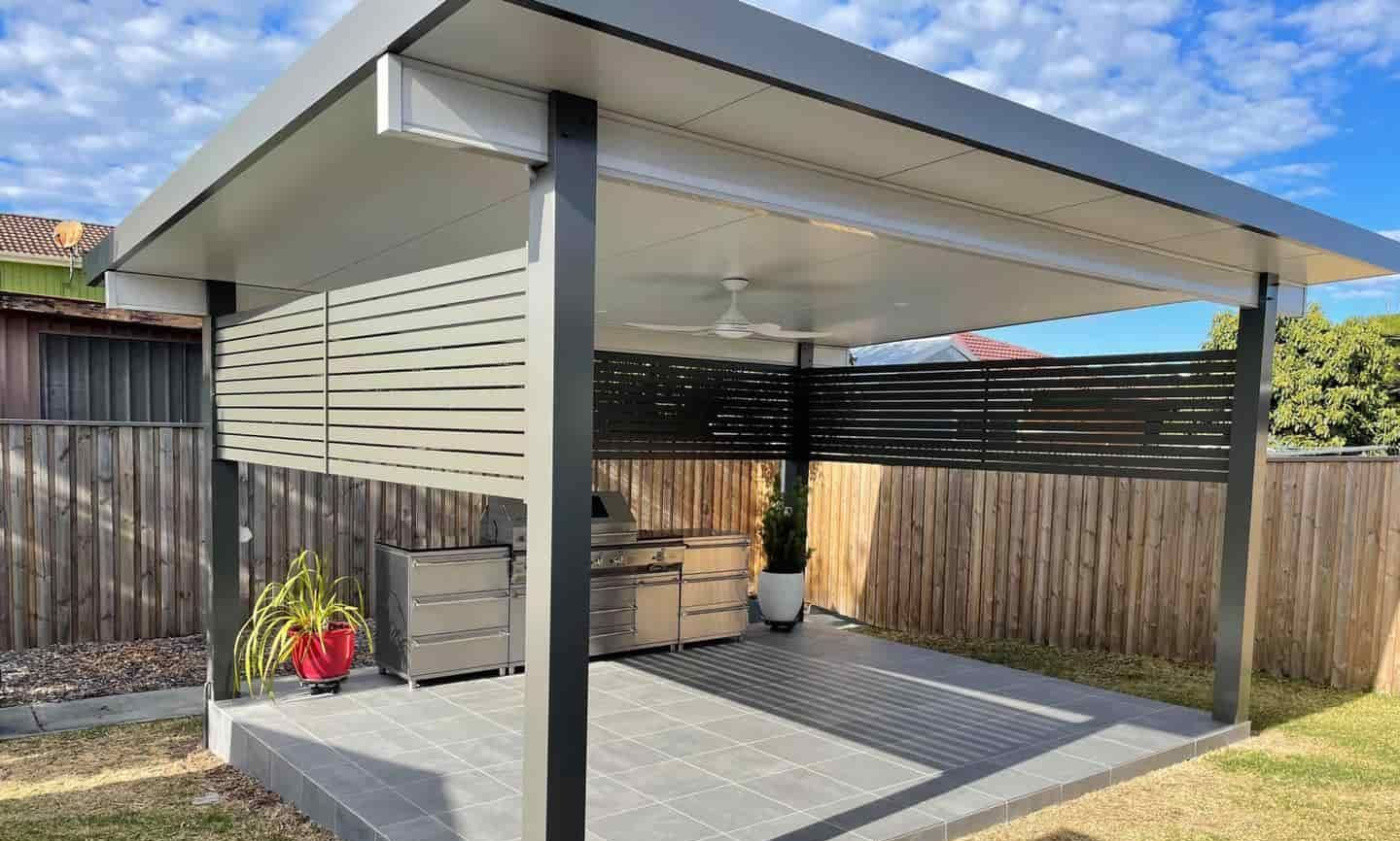 A Covered Patio With A Grill And A Ceiling Fan In A Backyard — Caprice Home Additions In Taree, NSW