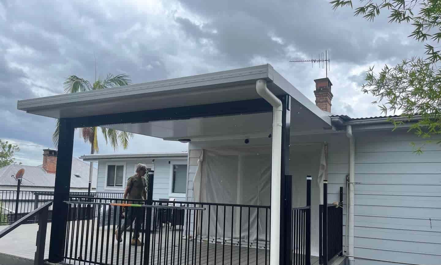 A White House With A Black Railing And A Covered Porch — Caprice Home Additions In Harrington, NSW