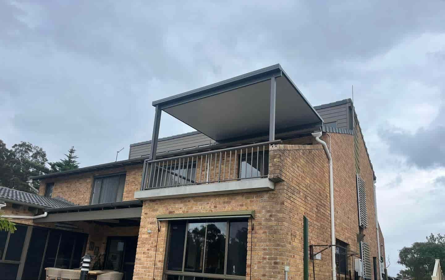 A Large Brick House With A Balcony On The Top Of It — Caprice Home Additions In Harrington, NSW