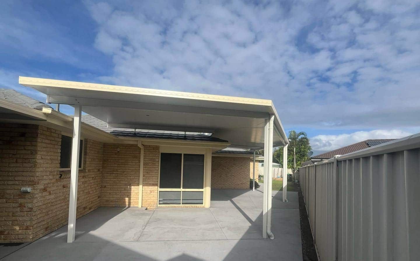 A Brick House With A Carport And A Fence In Front Of It — Caprice Home Additions In Harrington, NSW