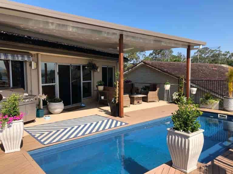 There Is A Large Swimming Pool In The Backyard Of A House — Caprice Home Additions In Taree, NSW