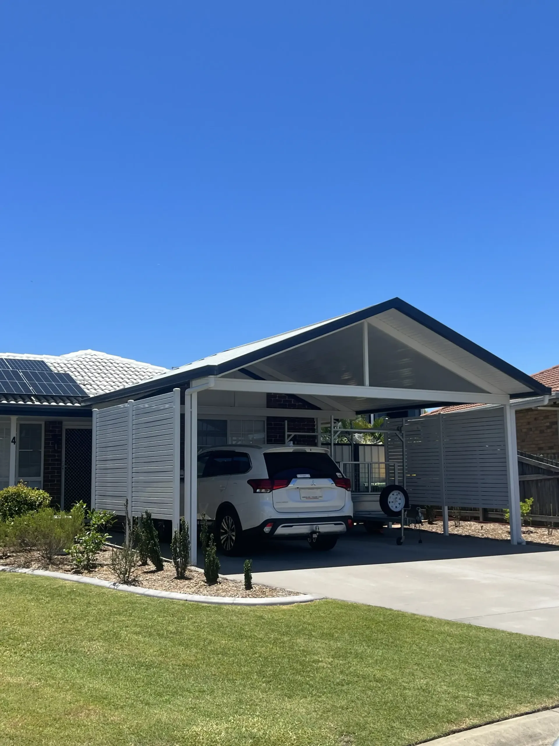 A Carport With A Roof And A Mailbox In Front Of A Brick House — Caprice Home Additions In Wingham, NSW