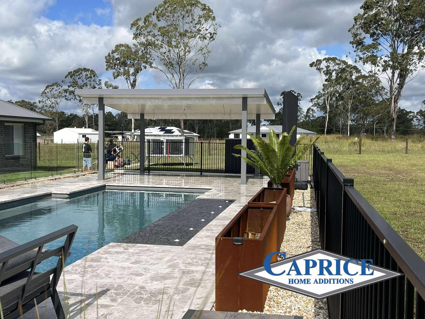 Modern Poolside Patio With Tiled Flooring And Grass
