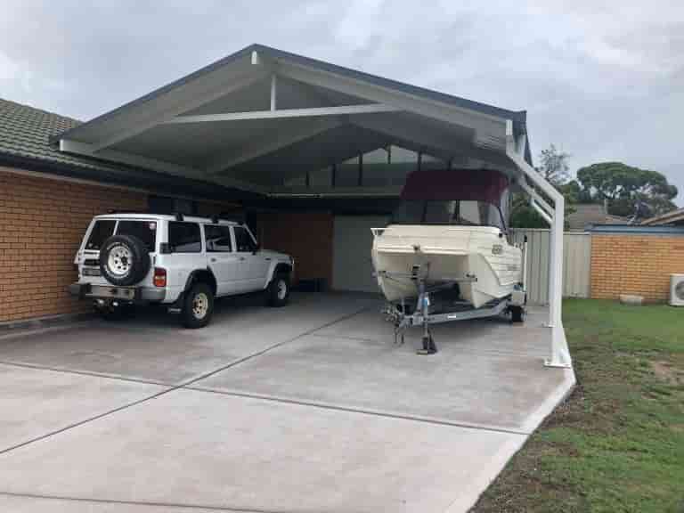A White SUV And A Boat Are Parked Under A Carport — Caprice Home Additions In Taree, NSW