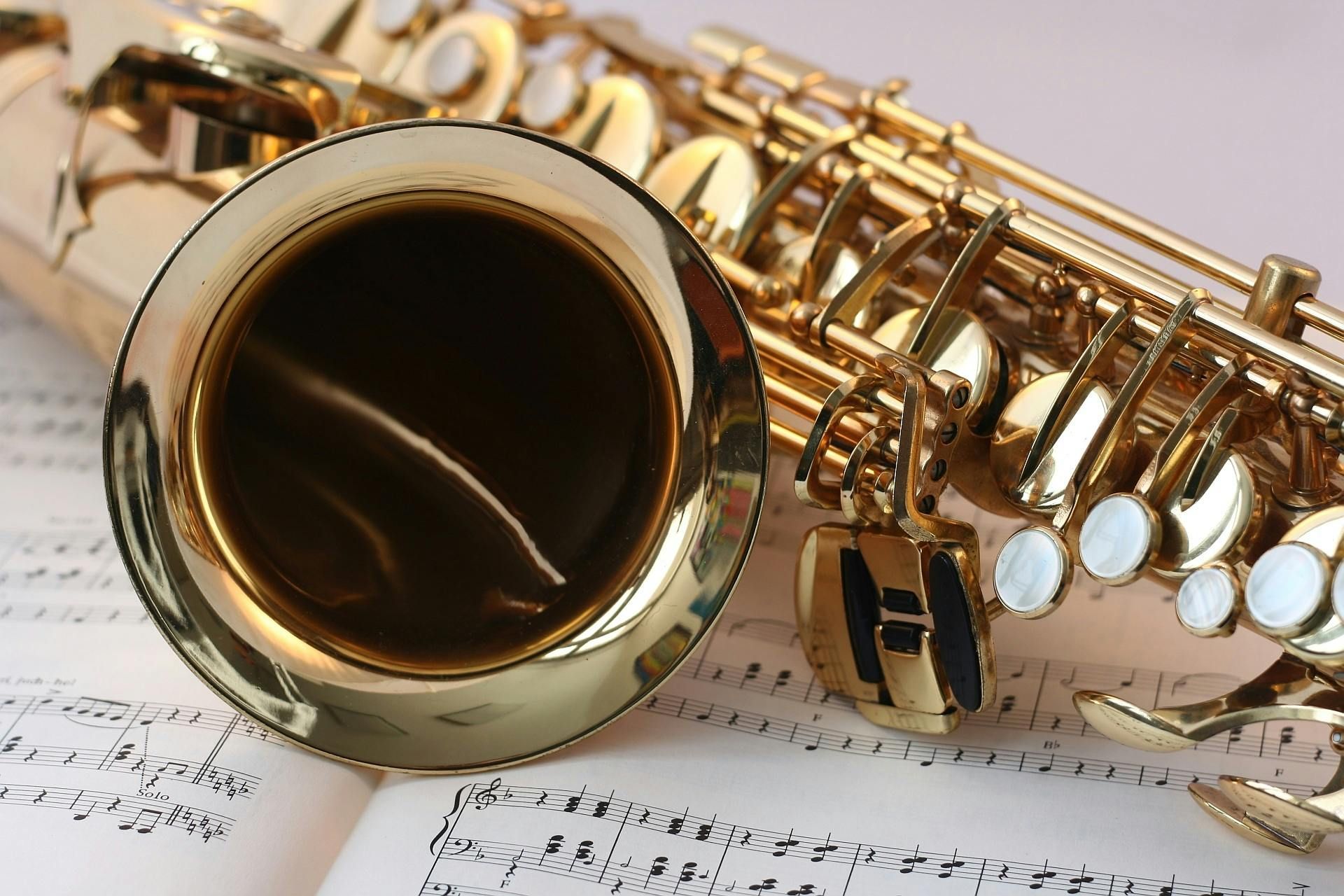 A close up of a saxophone on top of a sheet of music