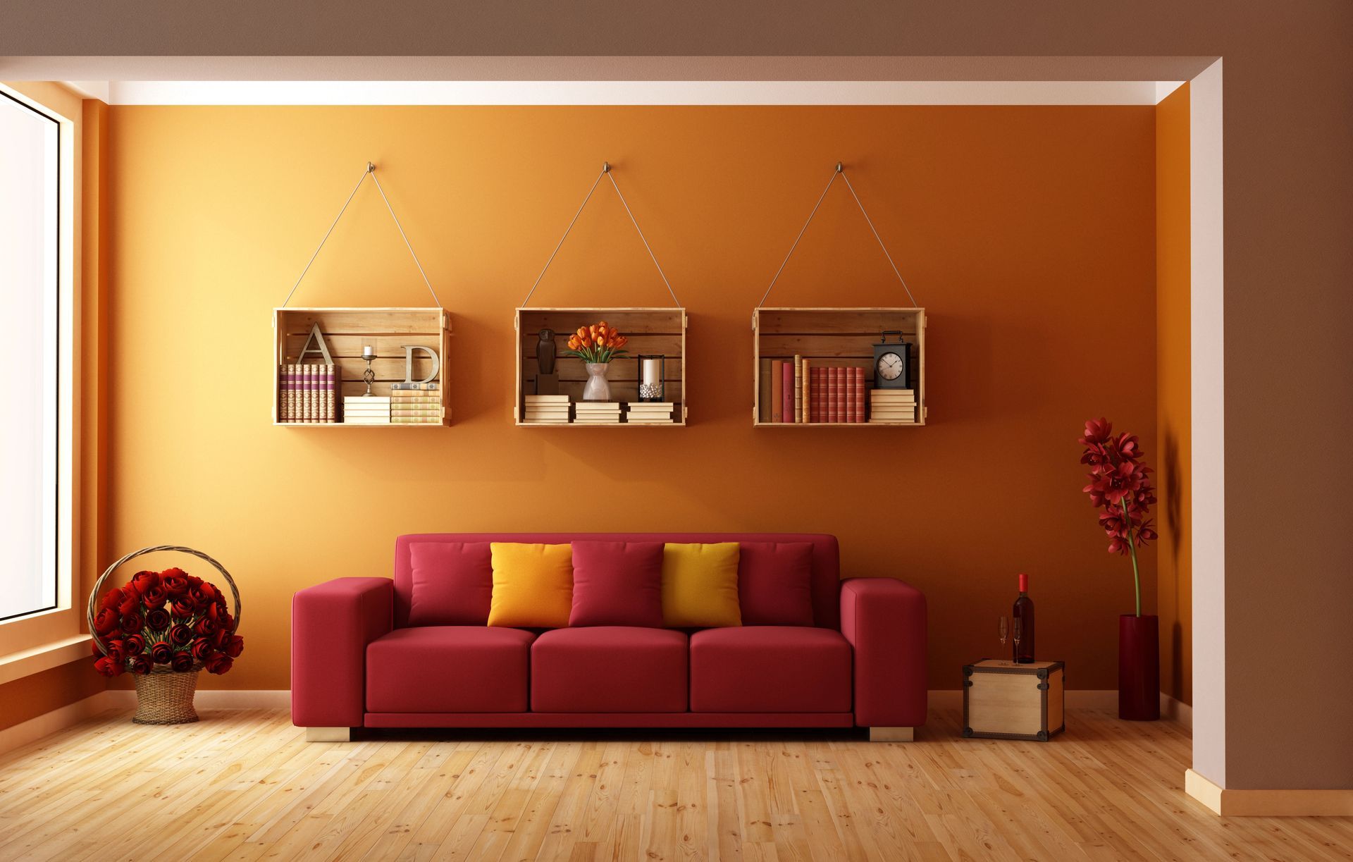 Living room with red sofa, orange wall, wooden shelves, and flowers.